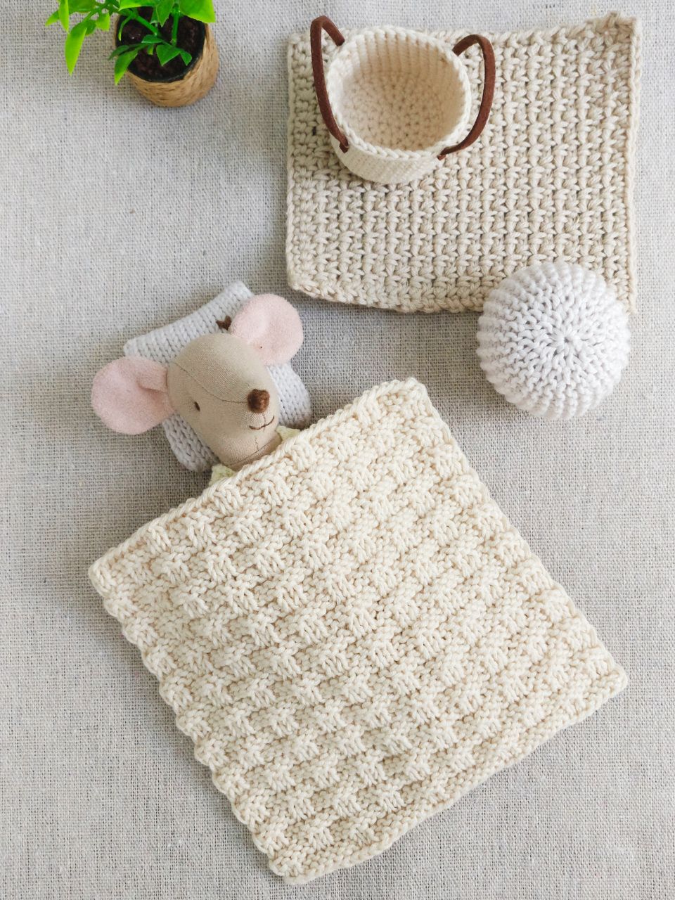 Maileg mouse tucked under a tiny hand-knitted blanket in a cozy miniature corner